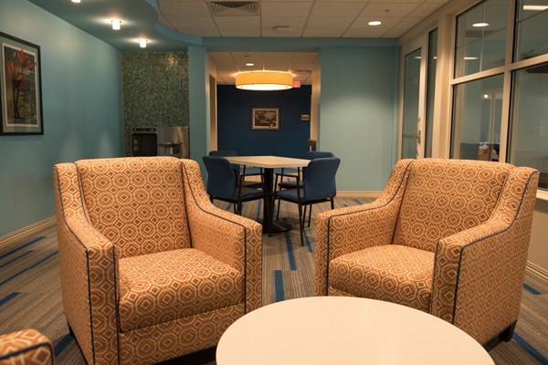 Two chairs in the foreground and a table and chairs behind.