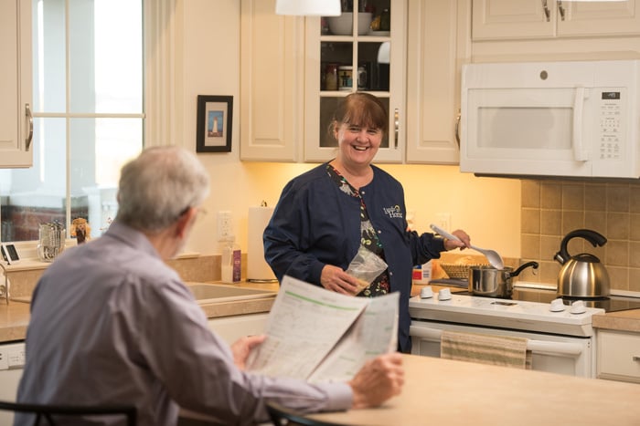 Resident conversing with caregiver in kitchen