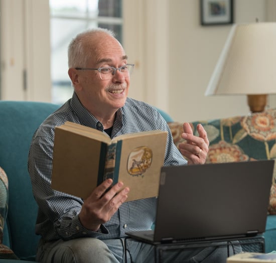 Man with book and computer