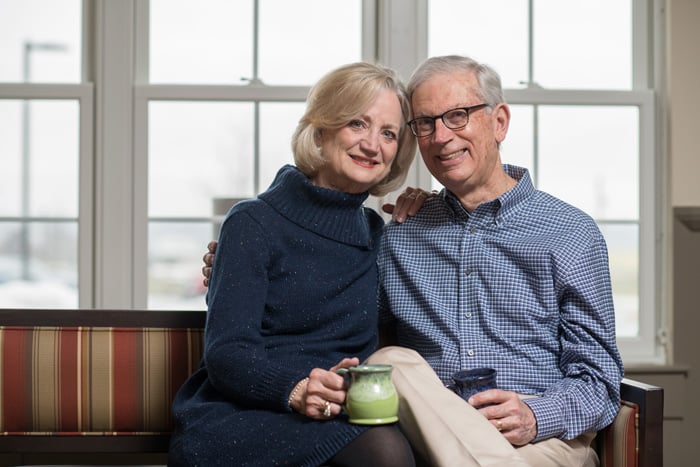 A senior couple holding coffee mugs