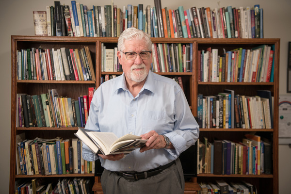 man in front of bookshelf