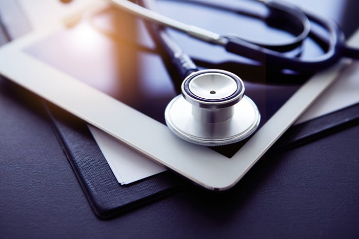 Close up of stethoscope and tablet on table.