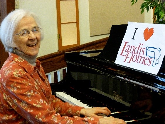 Ann Bigelow sitting at a piano. 