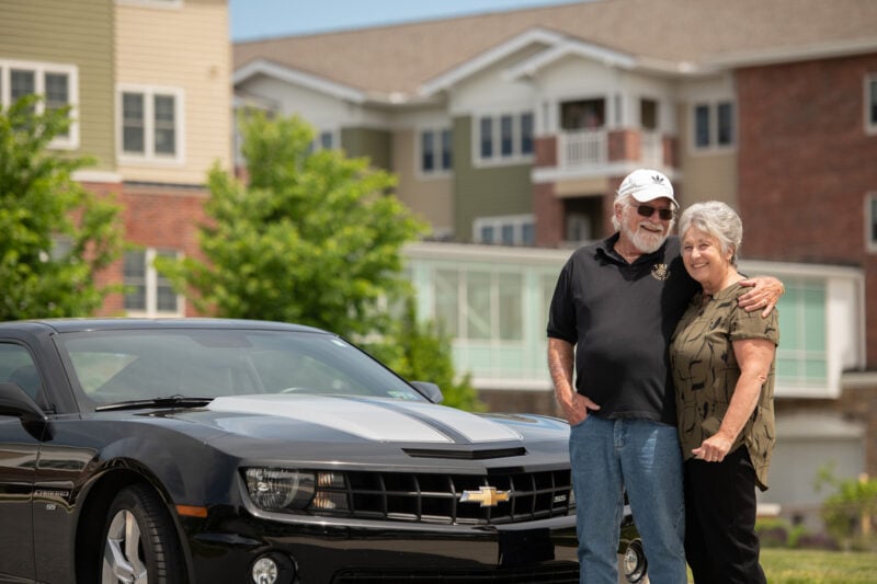 Senior couple standing by car